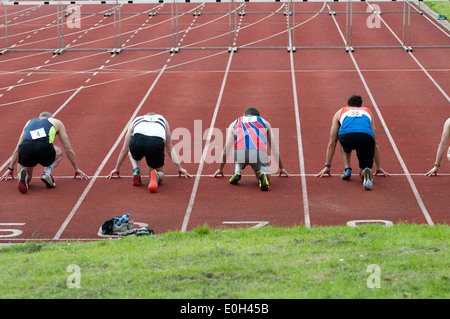 Athletics, runners at start of men`s 110m hurdles race at club level, UK Stock Photo